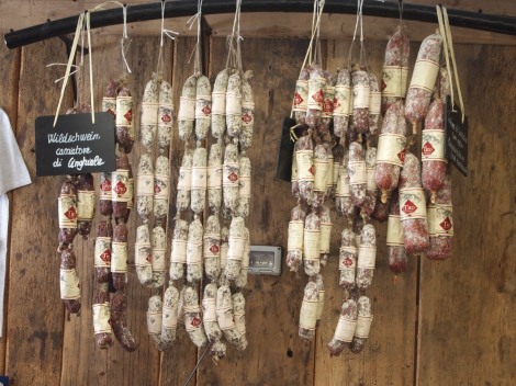 Sausages hanging in macelleria (butcher) selling cheeses, speciality meats, bacon, wine, breads and cookies.  We bought cheese and bread to take back on our bus. 